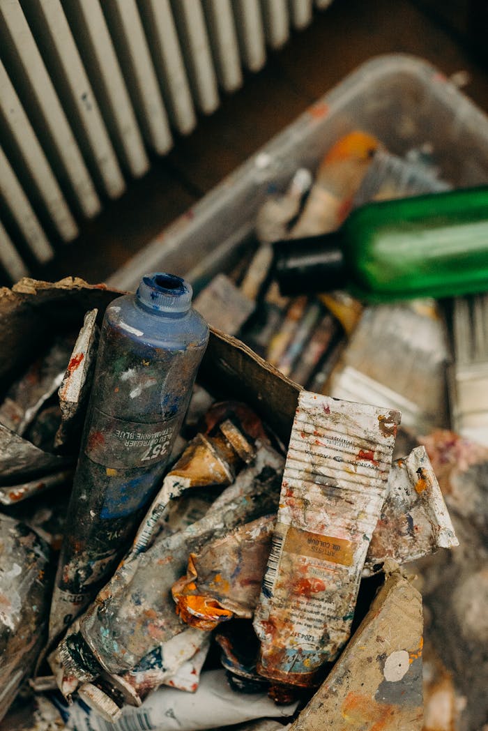 A creative mess of used paint tubes and plastic bottles, capturing an artistic chaos.